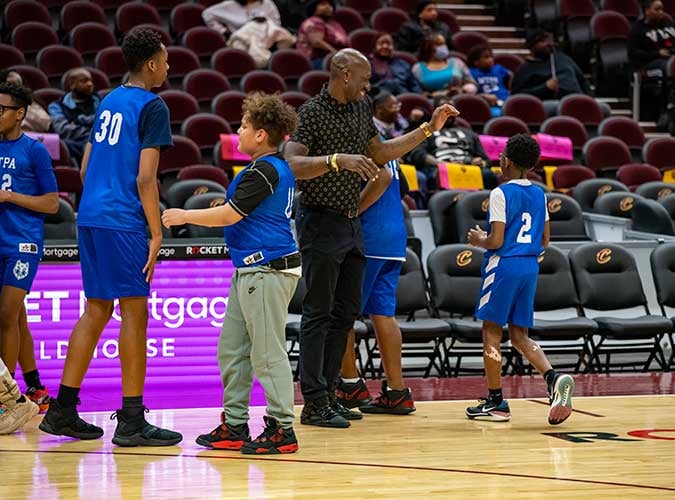Adult and children on a basketball court.