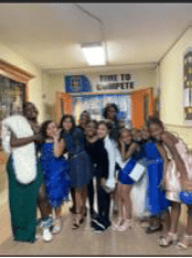 Adults and children in formal wear pose in a hallway.