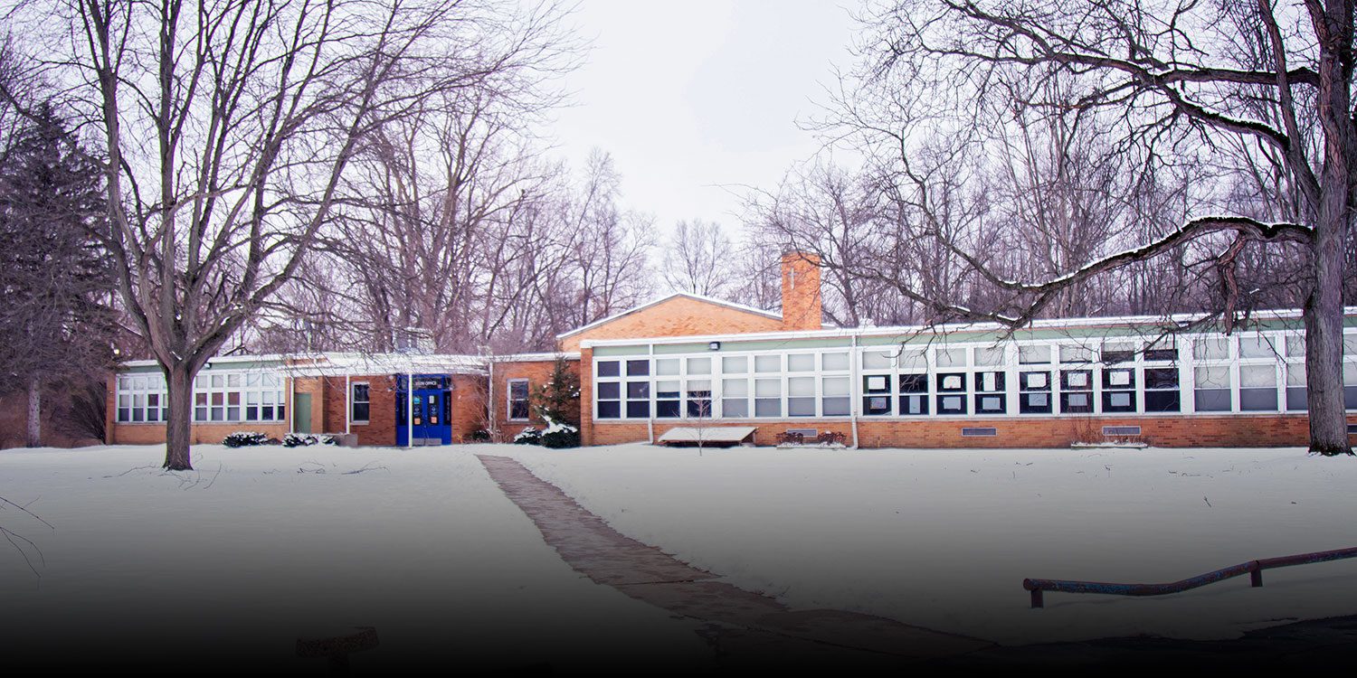 Western Toledo Preparatory Academy's brick school building in winter snow.