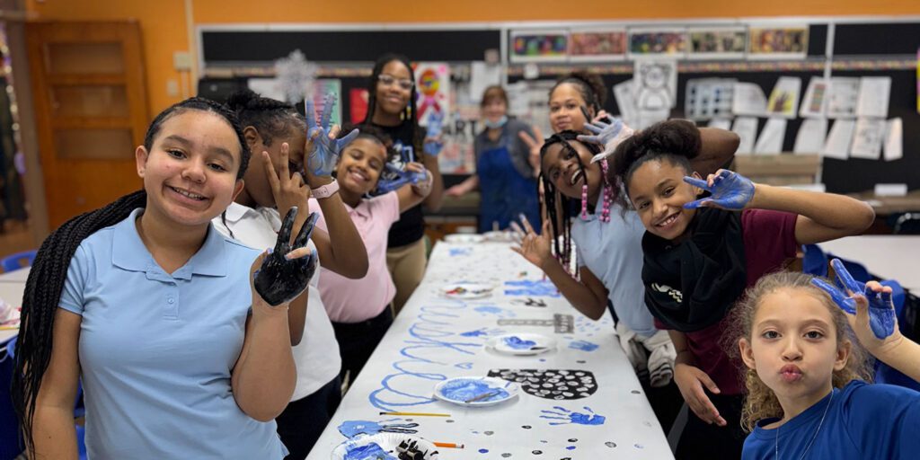 Smiling students doing a painting art project