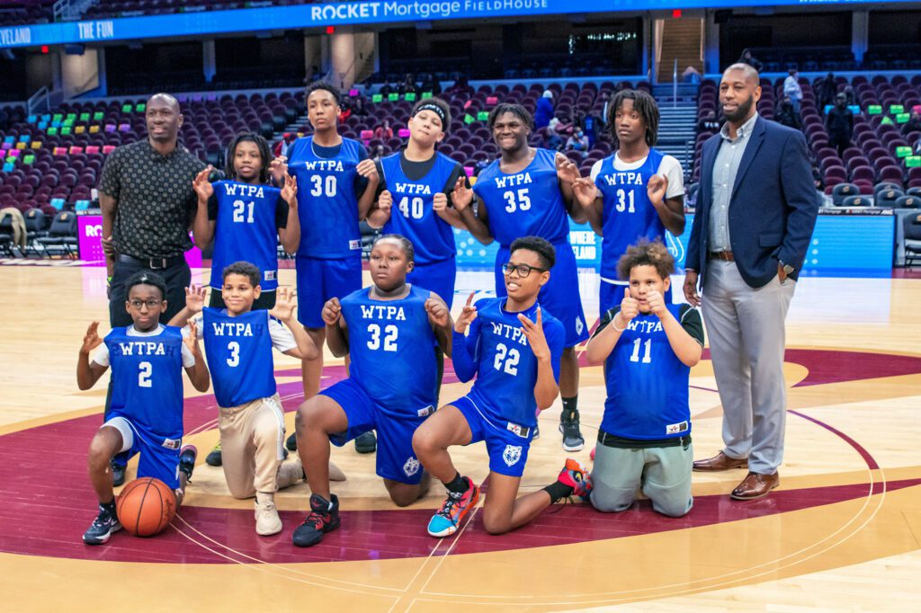 Basketball players and coach on the court.