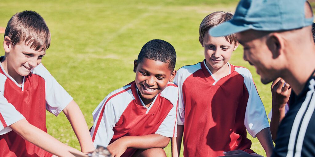 Smiling soccer players and coach on the filed
